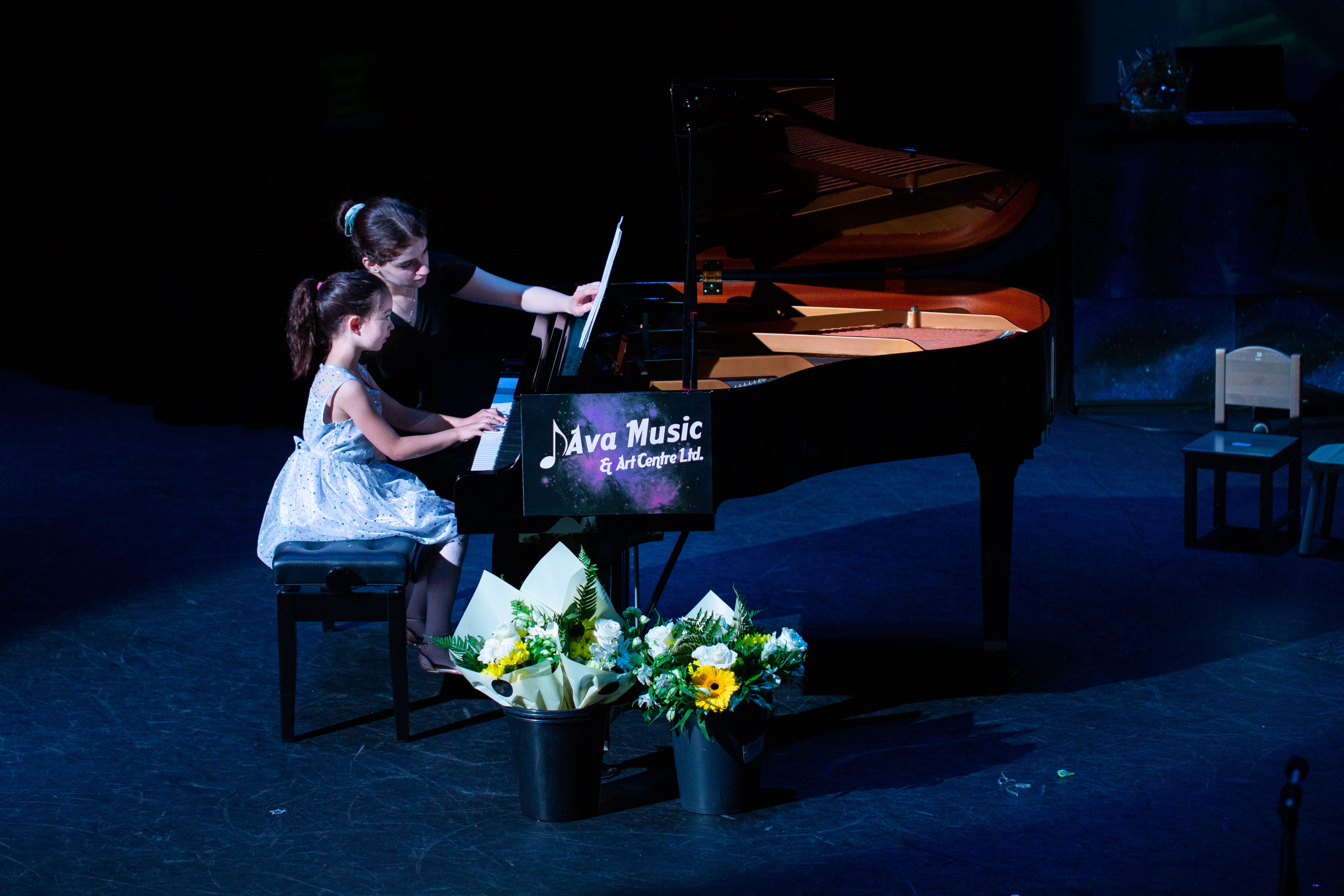 the instructor and student while playing the piano