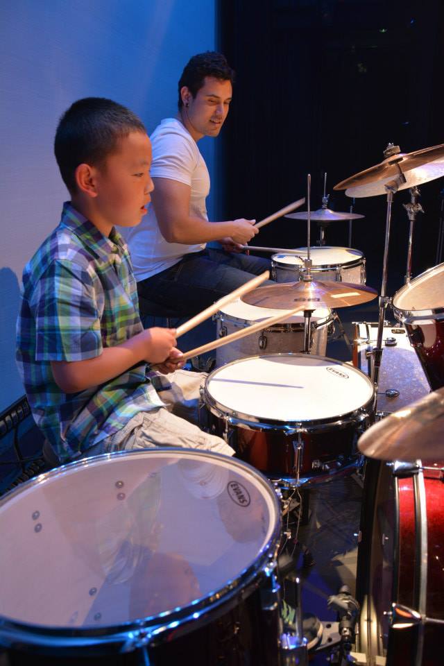 kid and instructor enjoying their drums