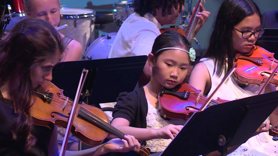 A girl trying to master the violin