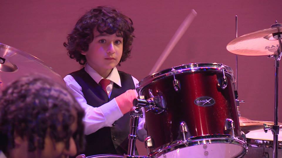 child mastering the drum