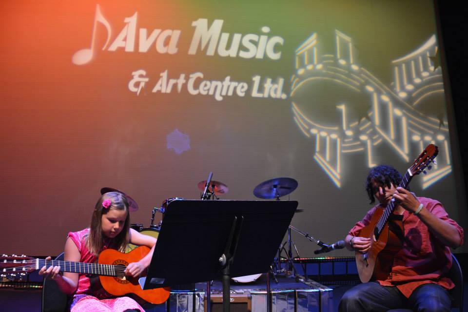 child and instructor playing guitars