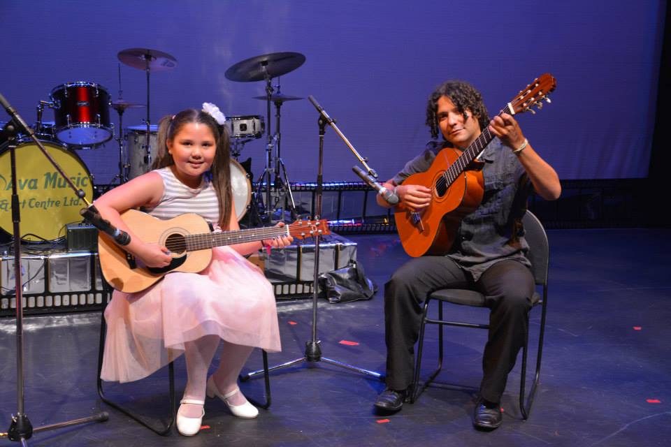 kid and instructor with their guitars