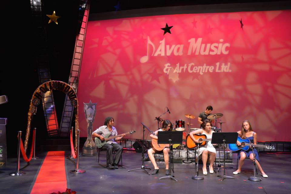 ladies and instructor enjoying their guitars