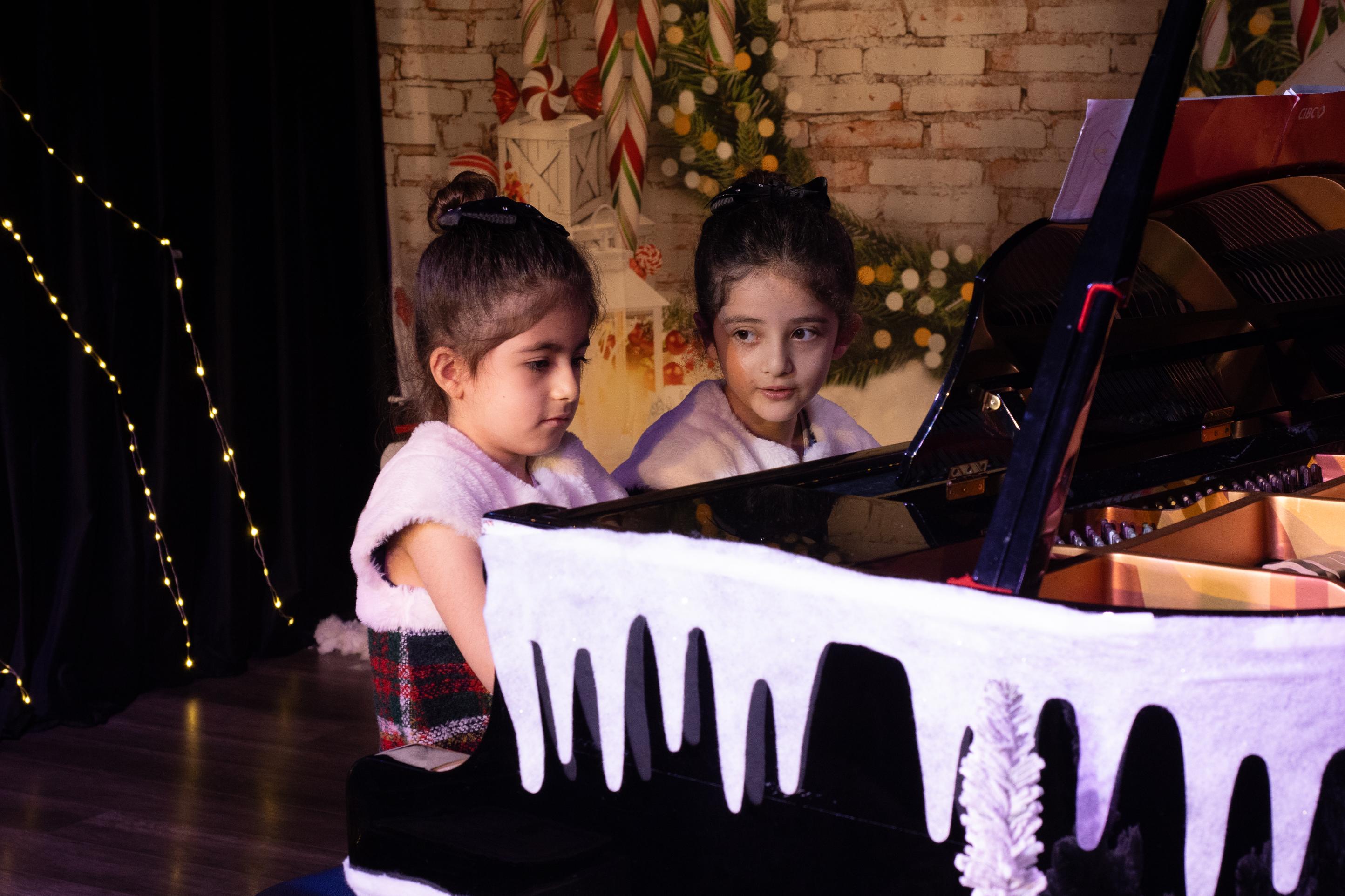 Young female artists in holiday performance on pian