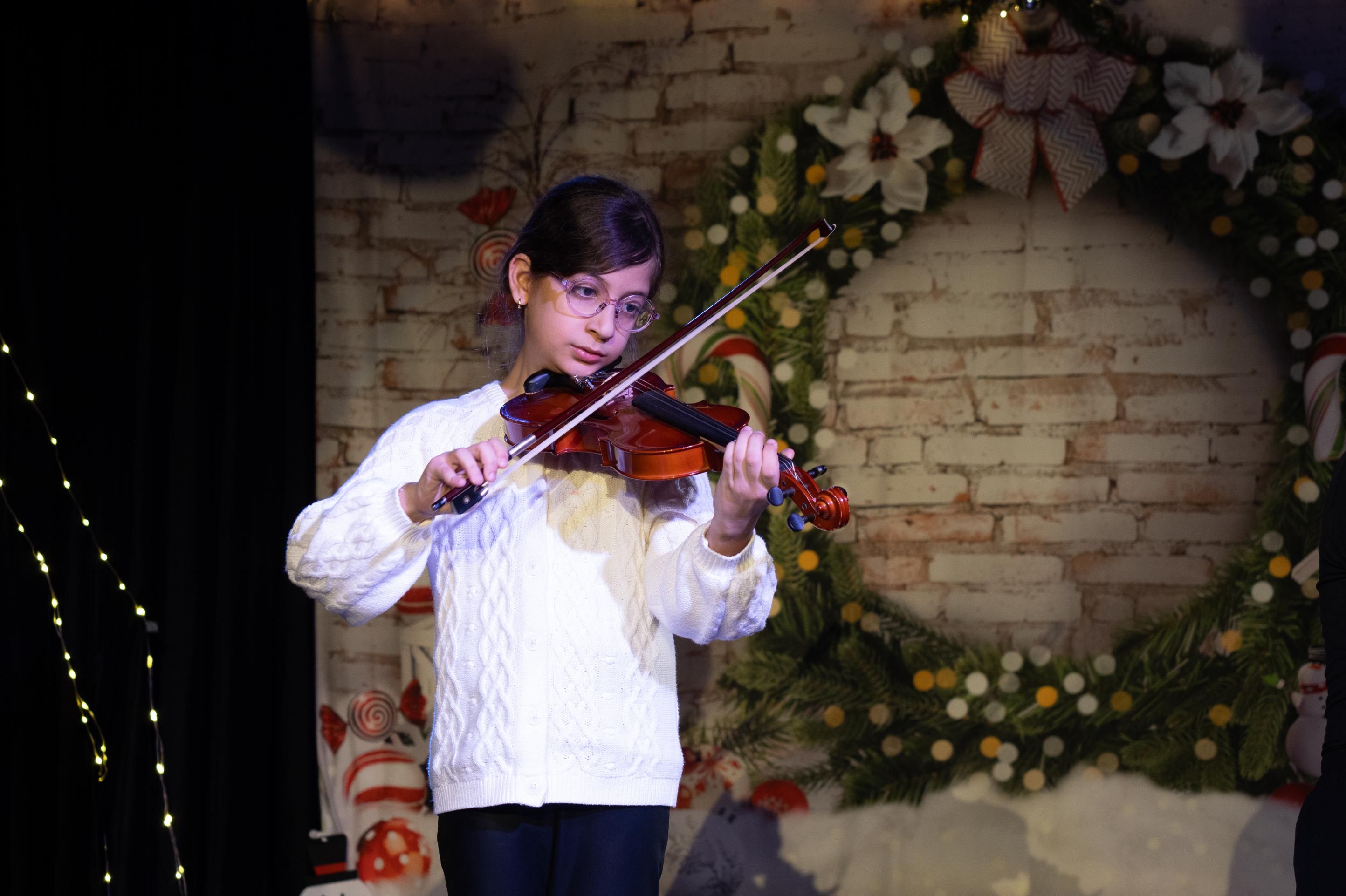 Child violinist on stage during holiday event