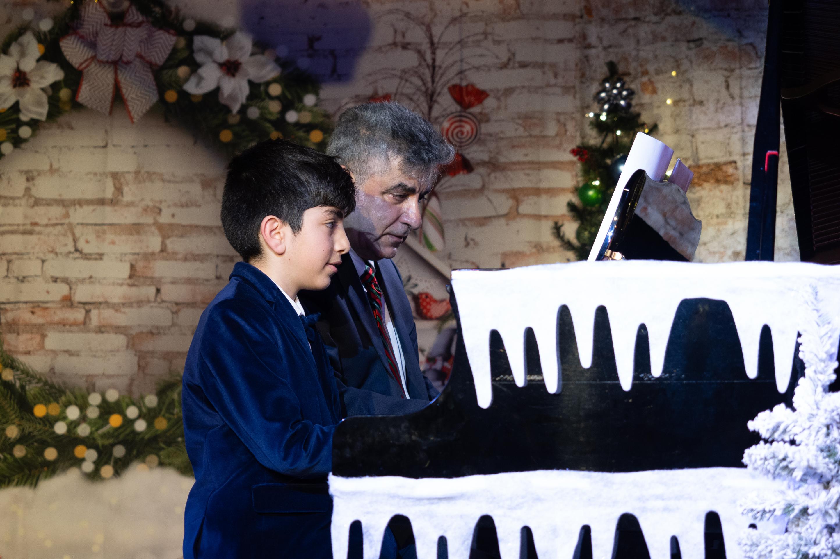 Talented boy and instructor playing classical holiday tunes on piano