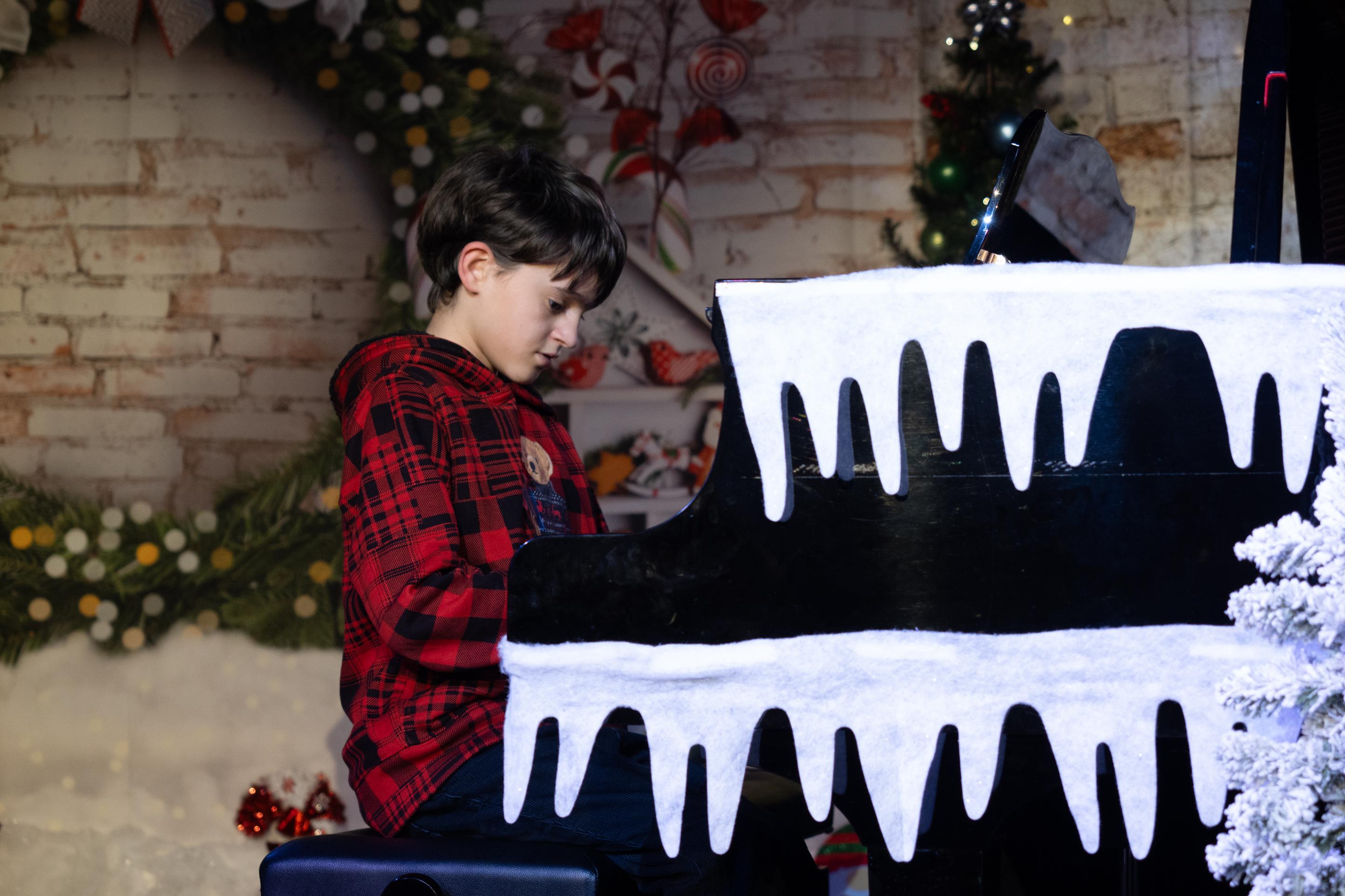 boy plays piano for a winter performance